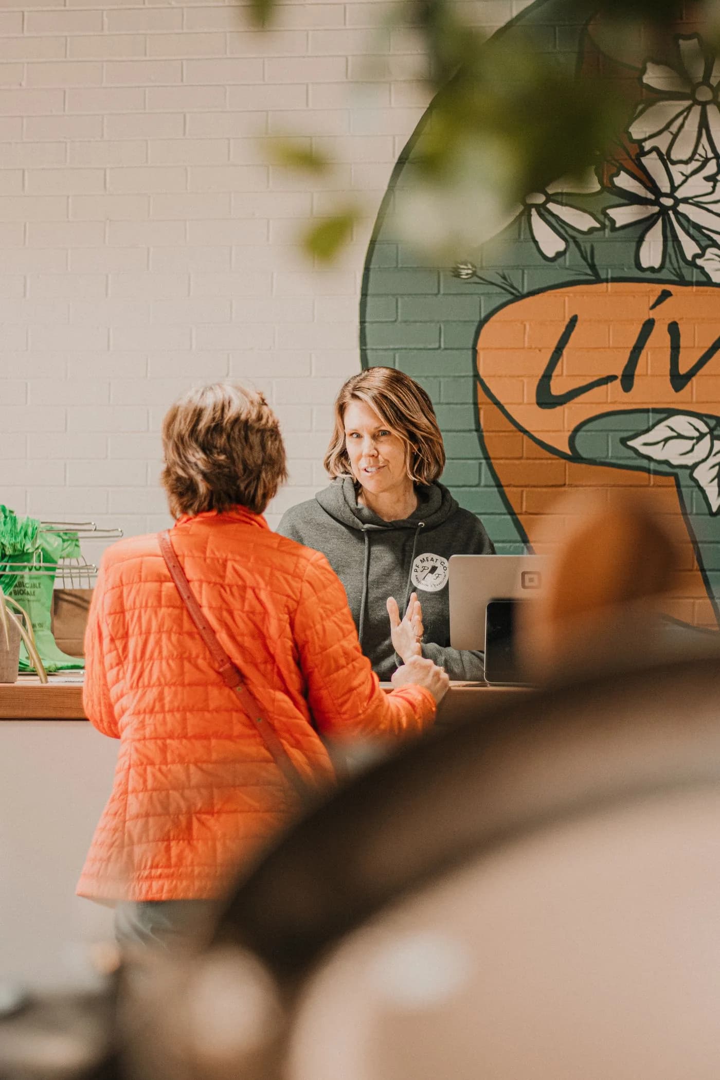 Two people talking across a local shop counter